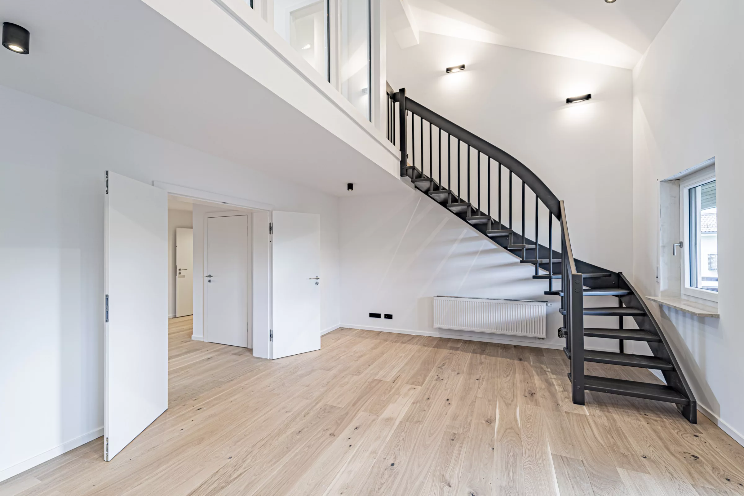 Moderne Wohnung mit Holzboden, Galerie und grauer Treppe in Gilching
