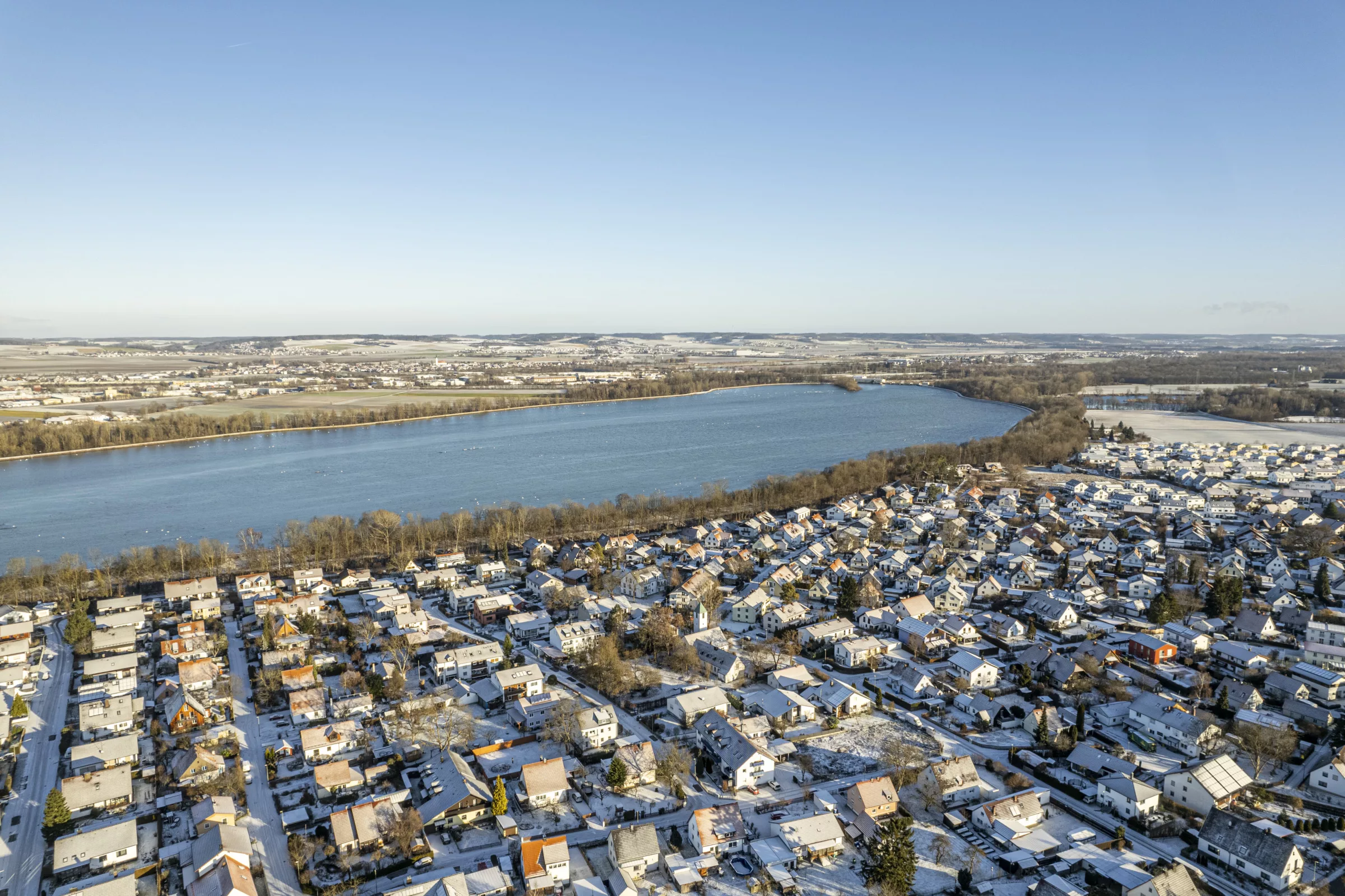 Drohnenflug über viele Häuser an einem See im Winter