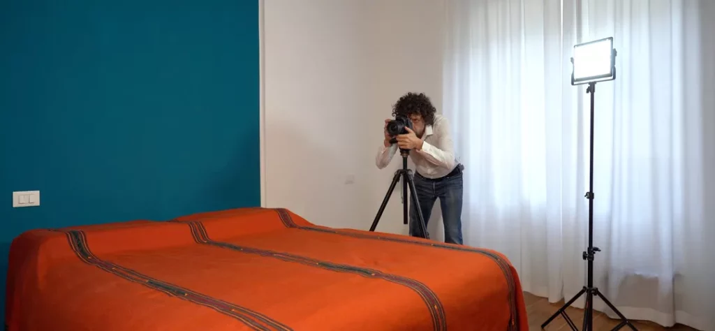 Mann erstellt mit Kamera und Licht Bilder von seiner Wohnung