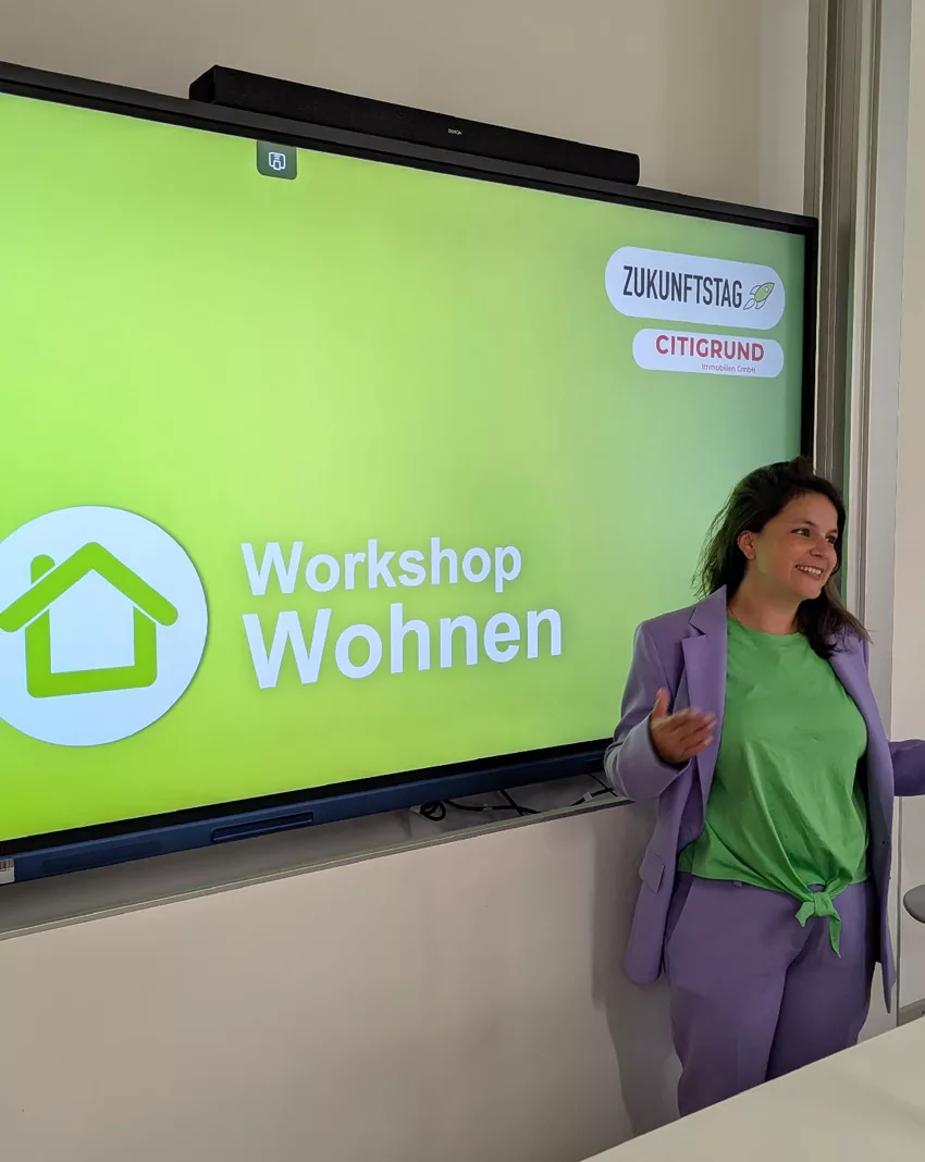 Edith Schwimmer steht vor einem Whiteboard mit ihrer Präsentation "Workshop Wohnen"