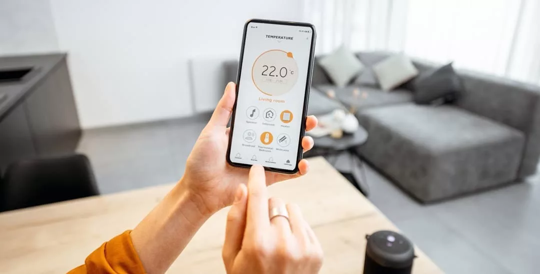 Person bedient Heizung am Smartphone über App