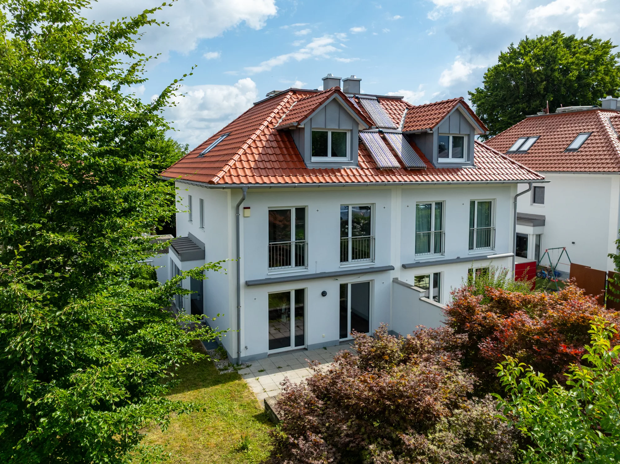 Modernes Haus mit Garten und Terrassenansicht.