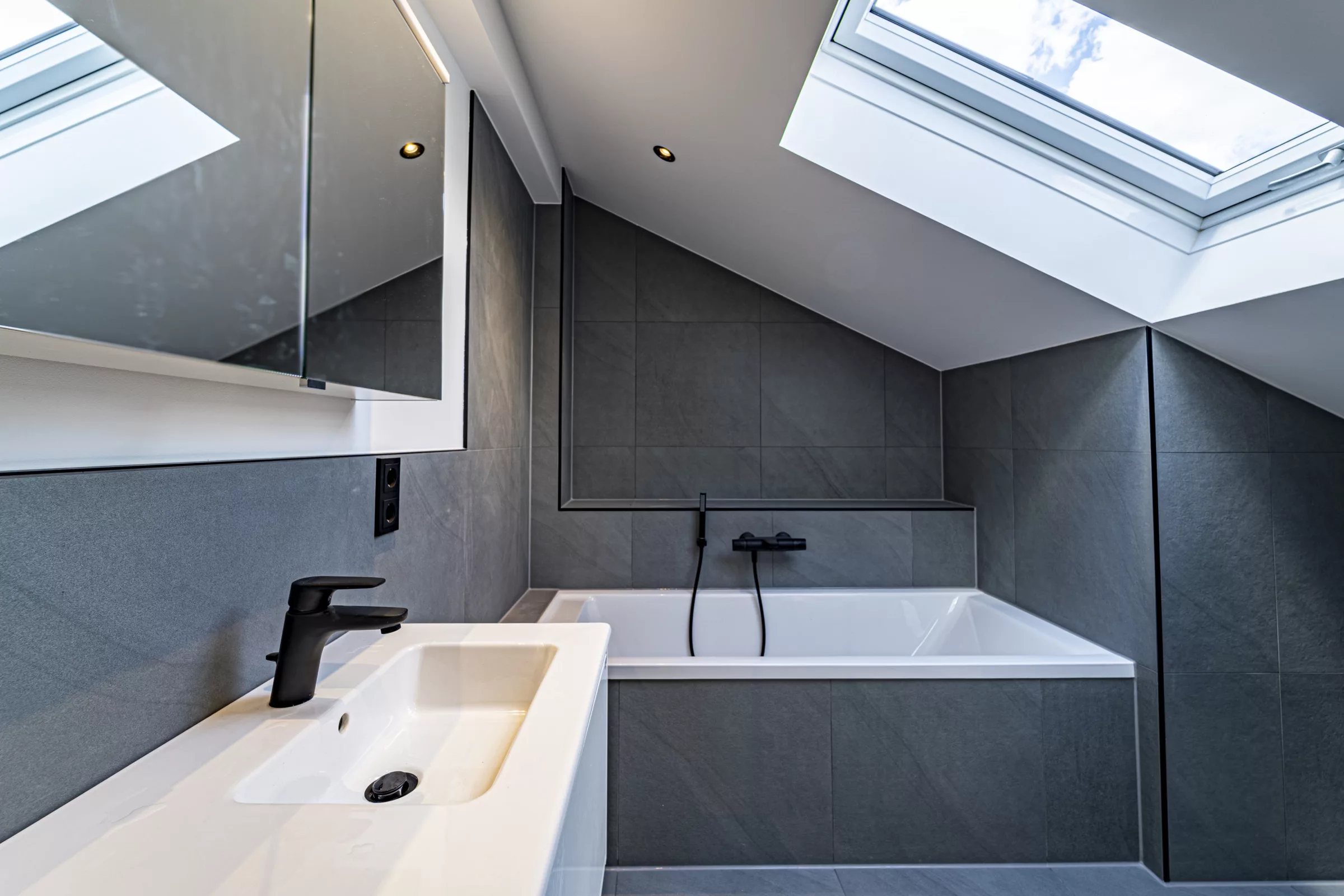 Modernes Badezimmer mit Dachfenster und Badewanne.