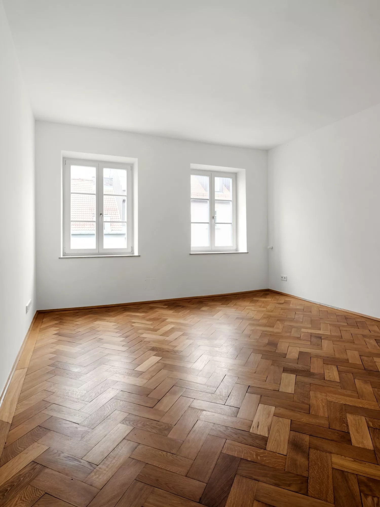 Heller Raum mit Holzfußboden und Fenstern