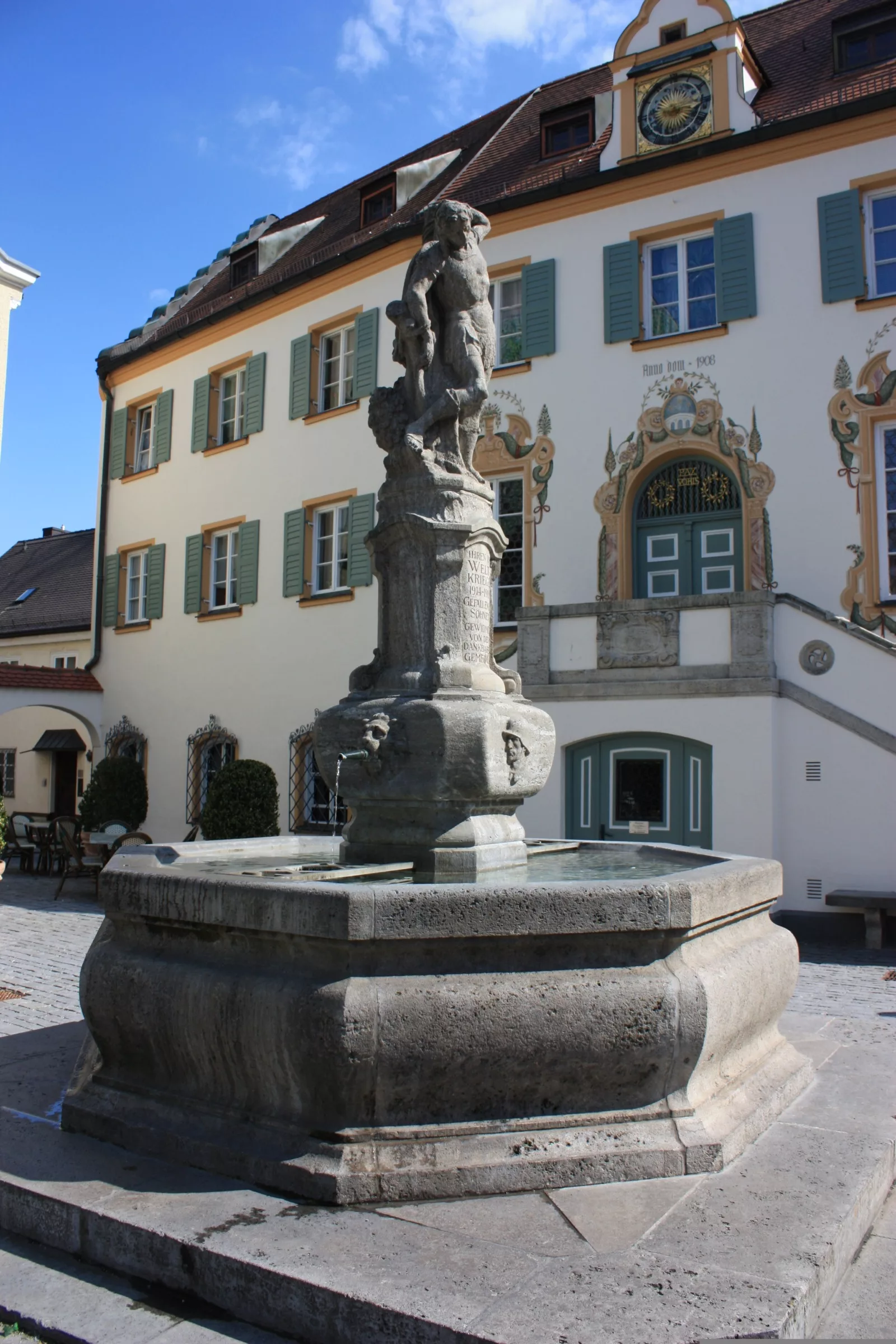 Historischer Brunnen mit Statue im Innenhof.