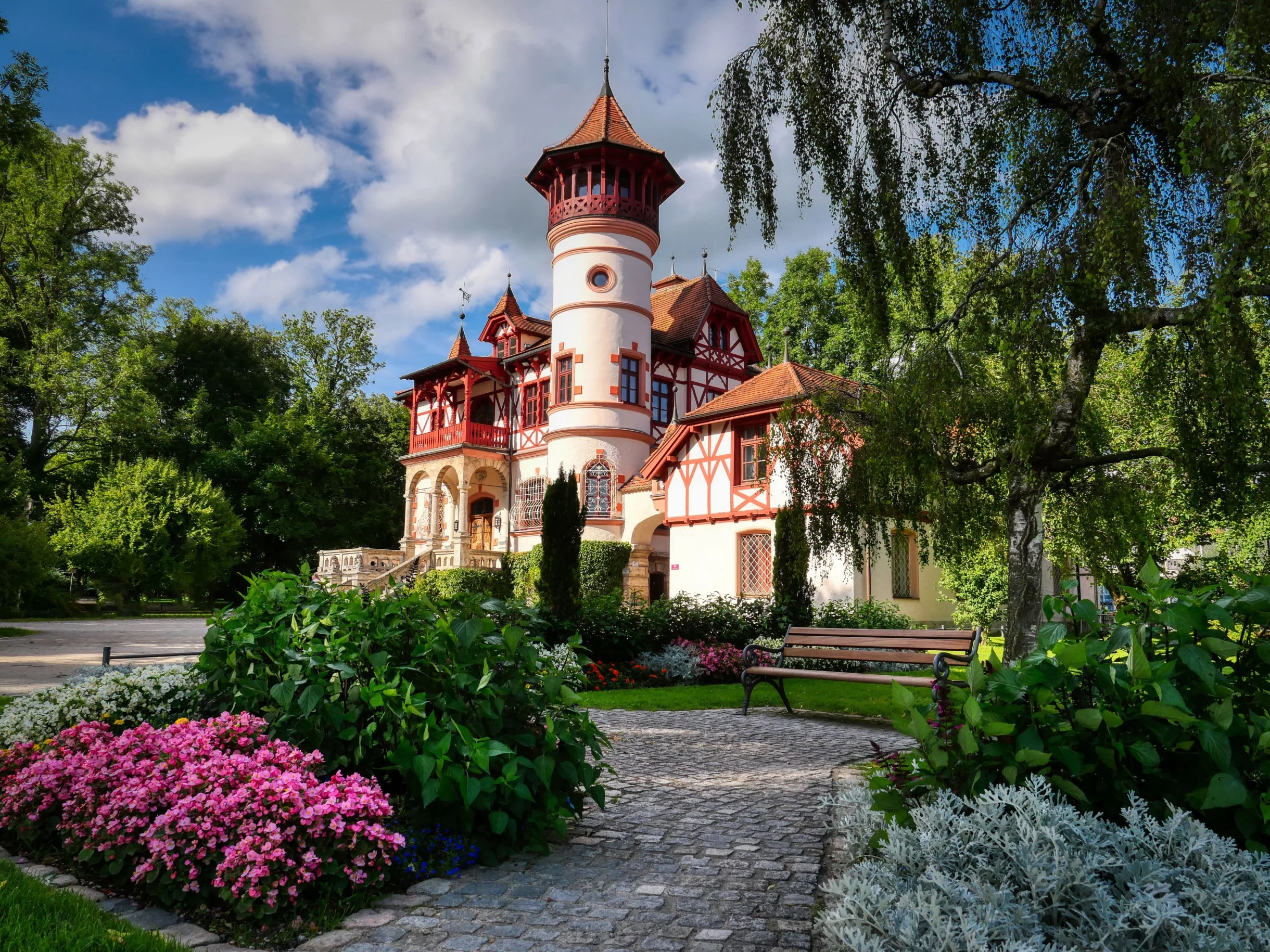 Schönes, historisches Gebäude mit blühendem Garten.