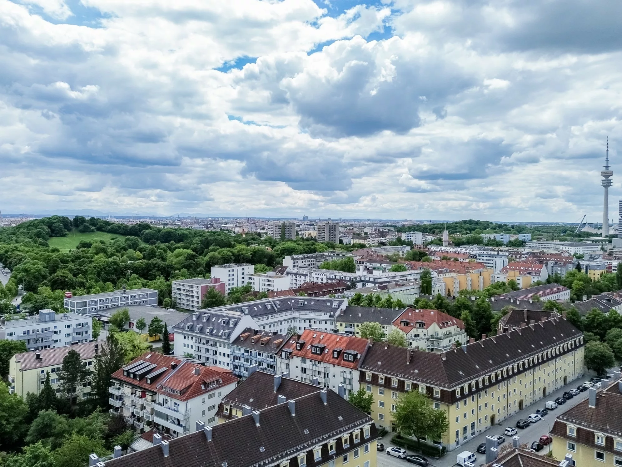 Blick über die Stadt mit Wolken und Grünflächen