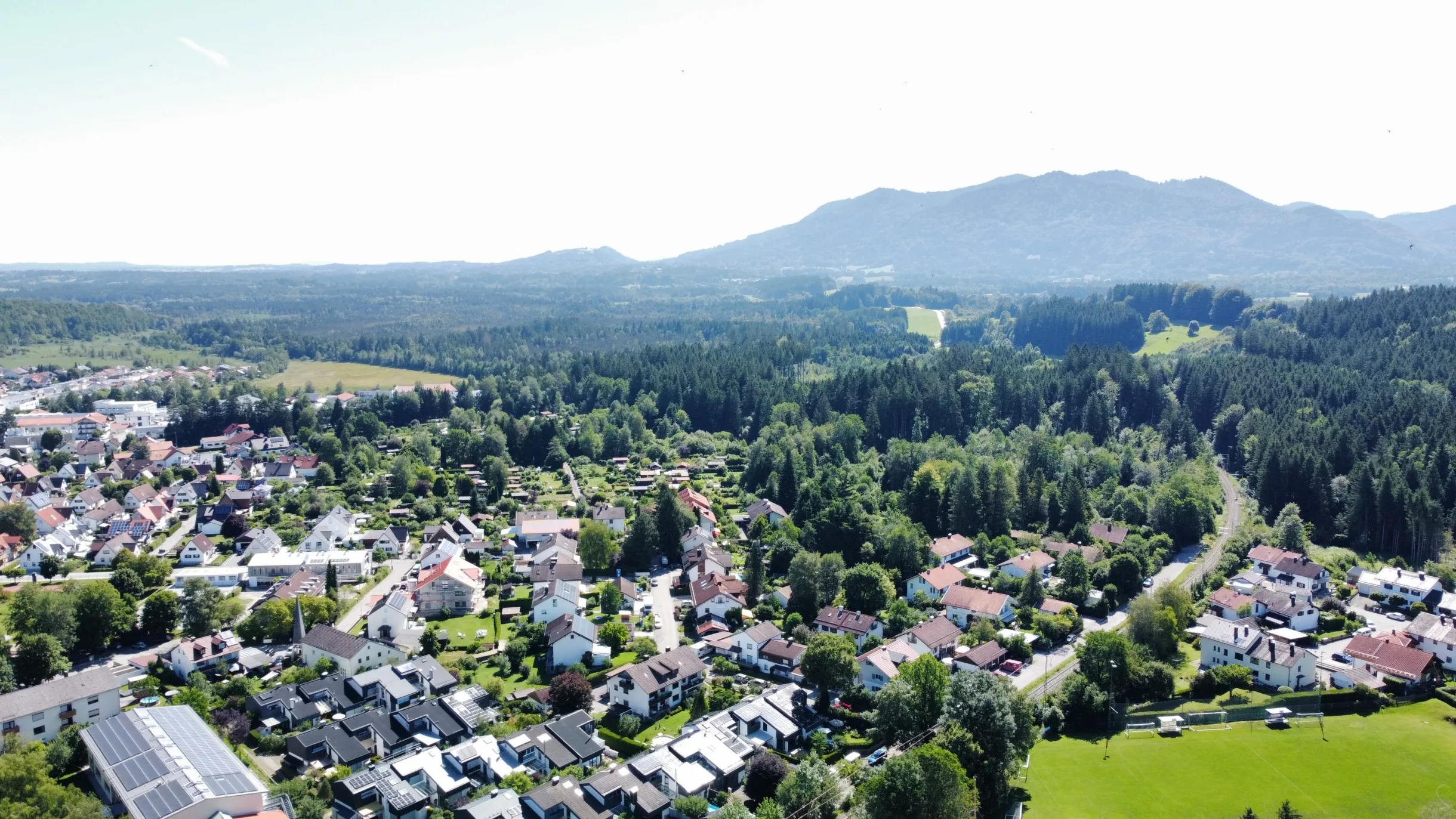 Landschaft mit Häusern und Bergen im Hintergrund von Penzberg