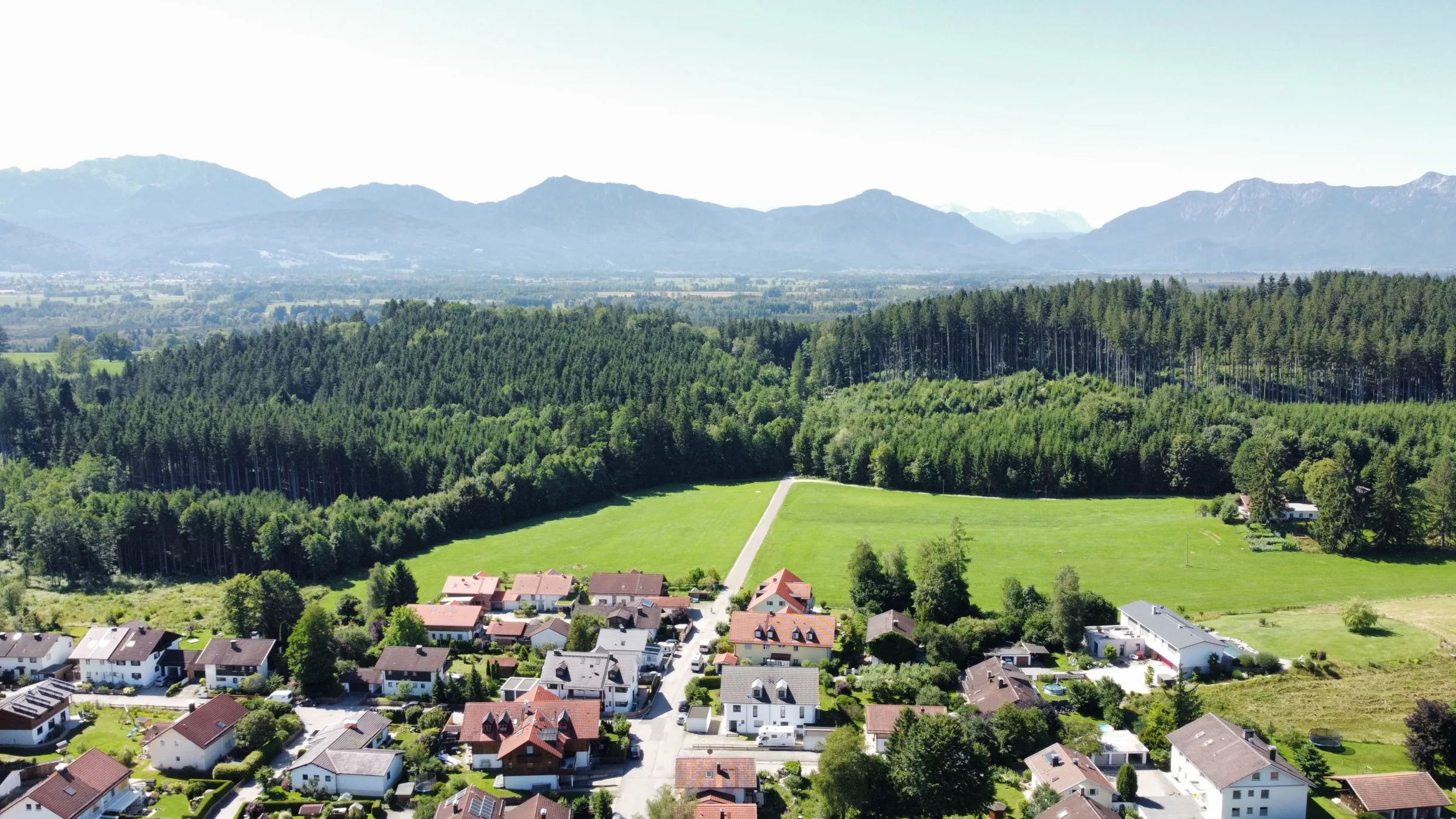 Landschaft mit Bergen und Häusern im Vordergrund in Penzberg
