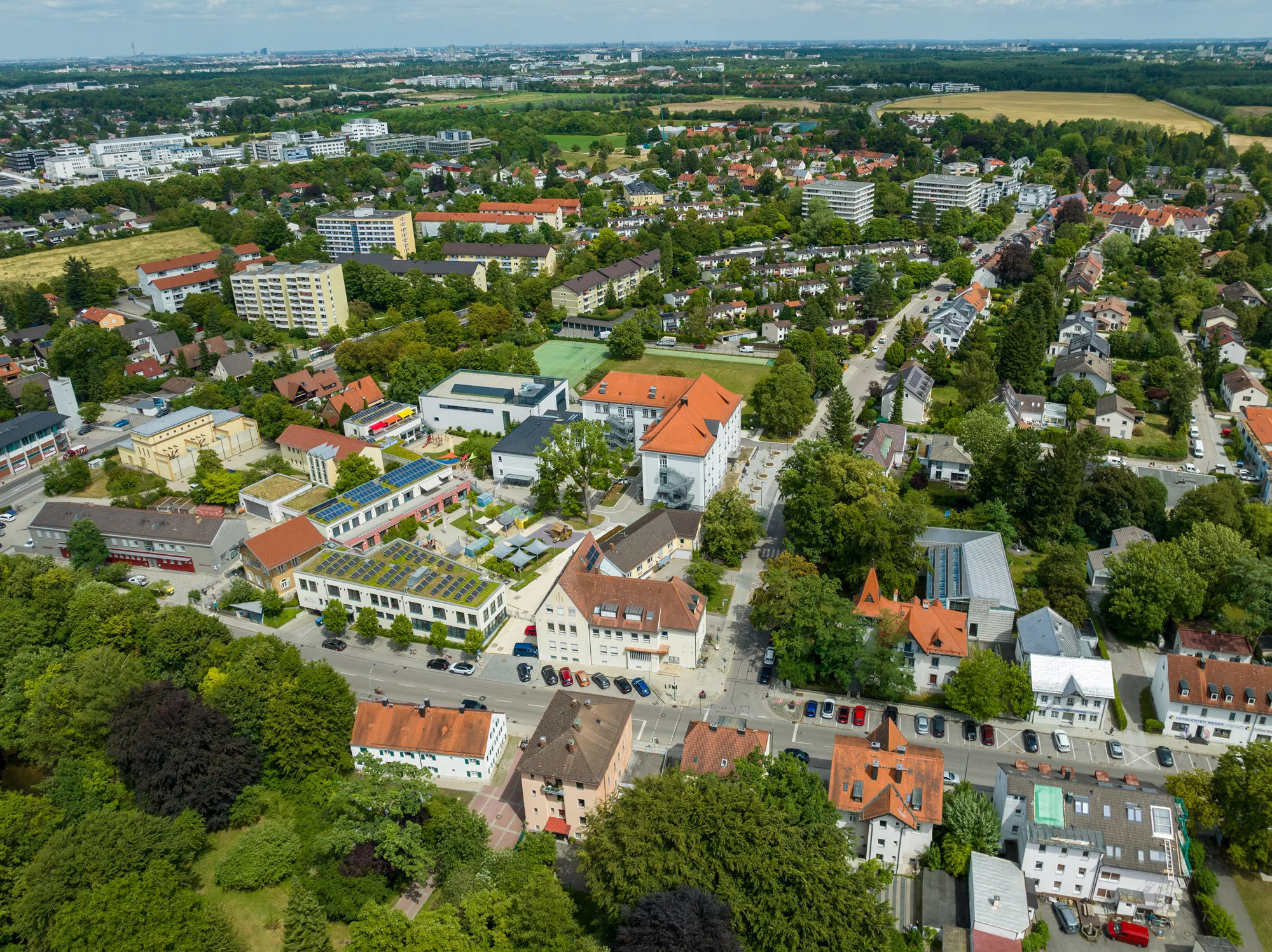 Luftaufnahme einer Stadt mit grünen Flächen.