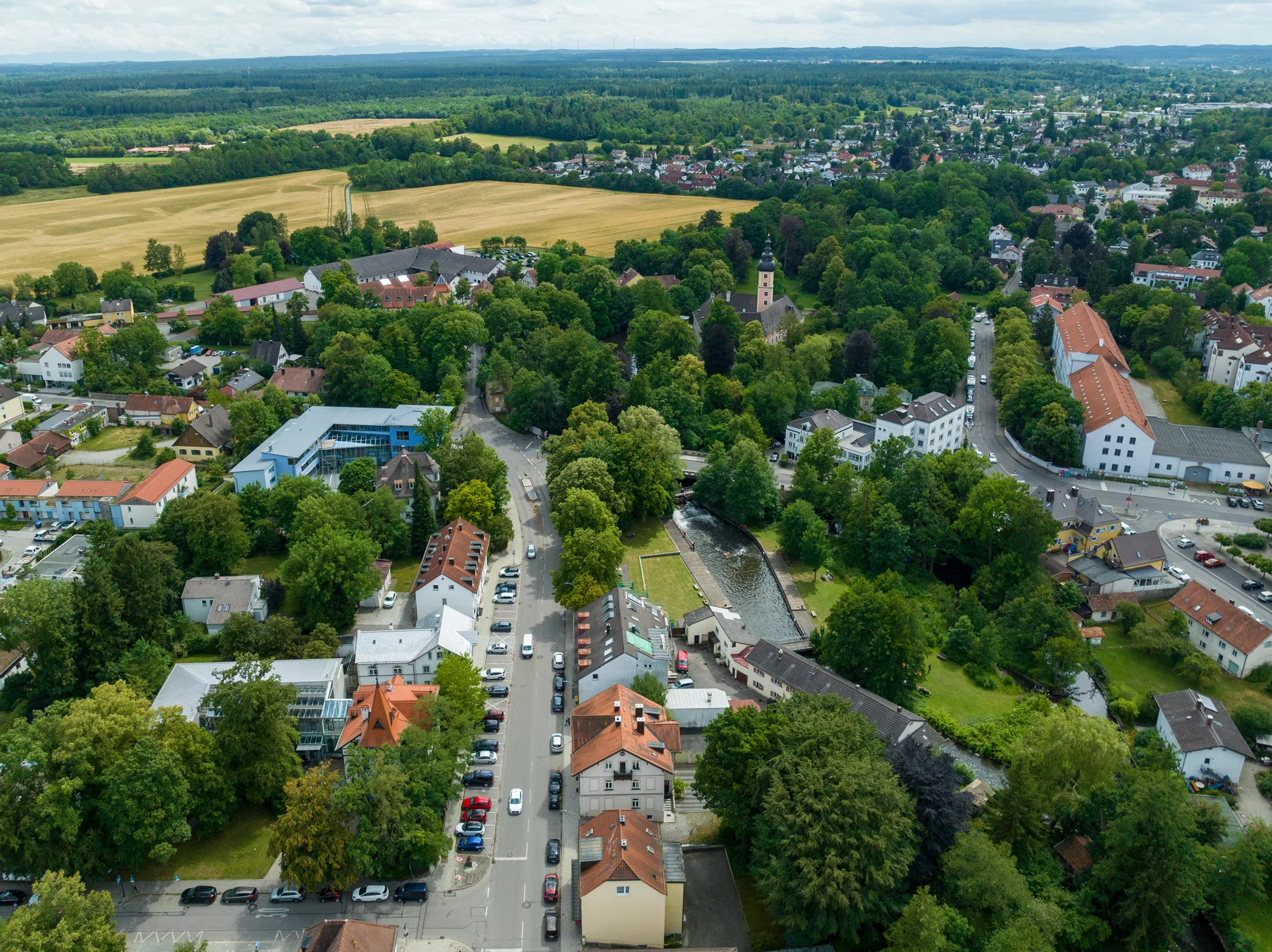 Luftaufnahme einer Stadt umgeben von Feldern und Wäldern.