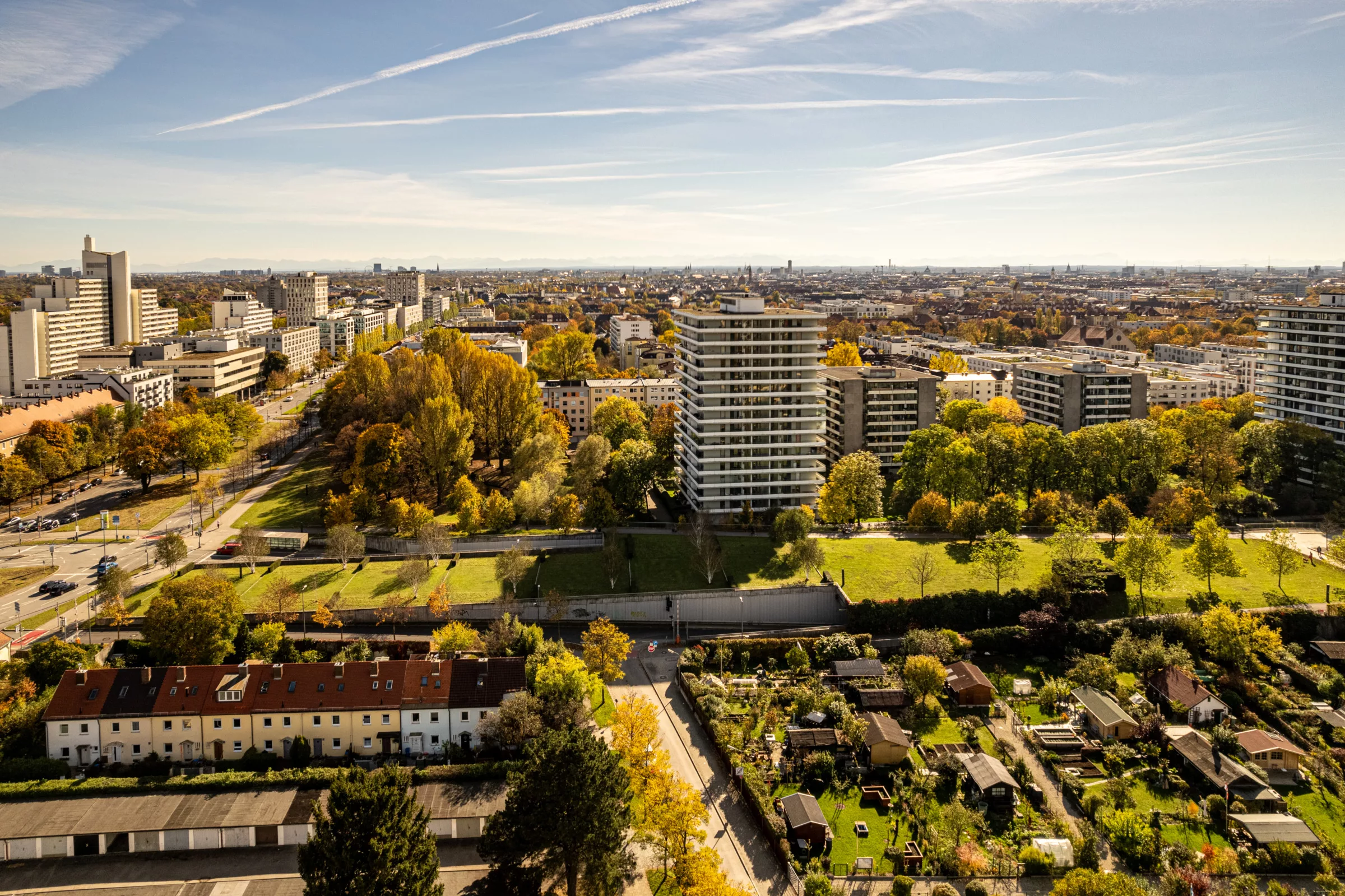 Stadtansicht von Schwabing mit Herbstbäumen und modernen Gebäuden.