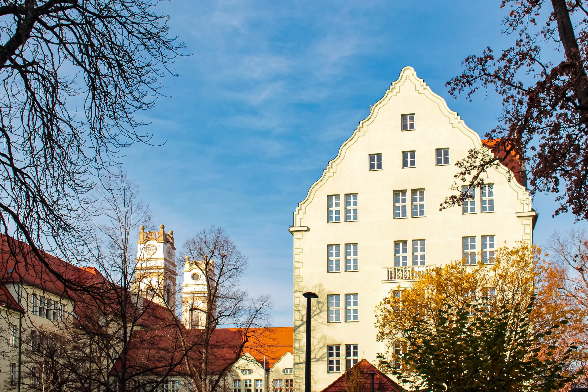 Historisches Gebäude mit auffälliger Architektur und Bäumen in Sendling