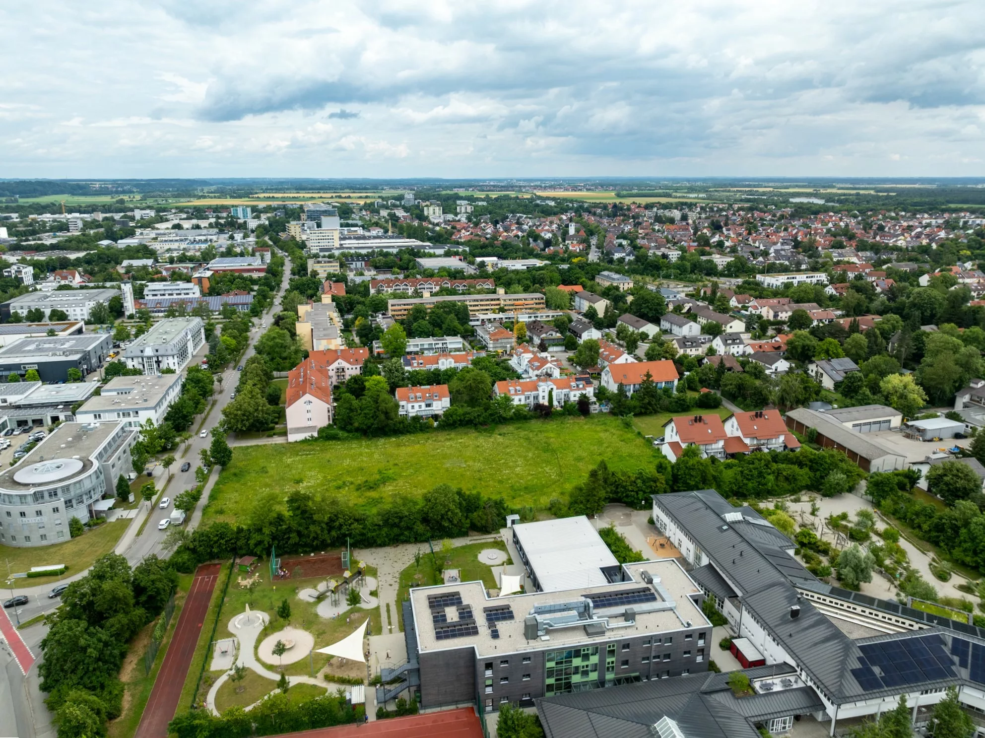 Luftaufnahme einer Stadt mit Wohngebieten und Parks.
