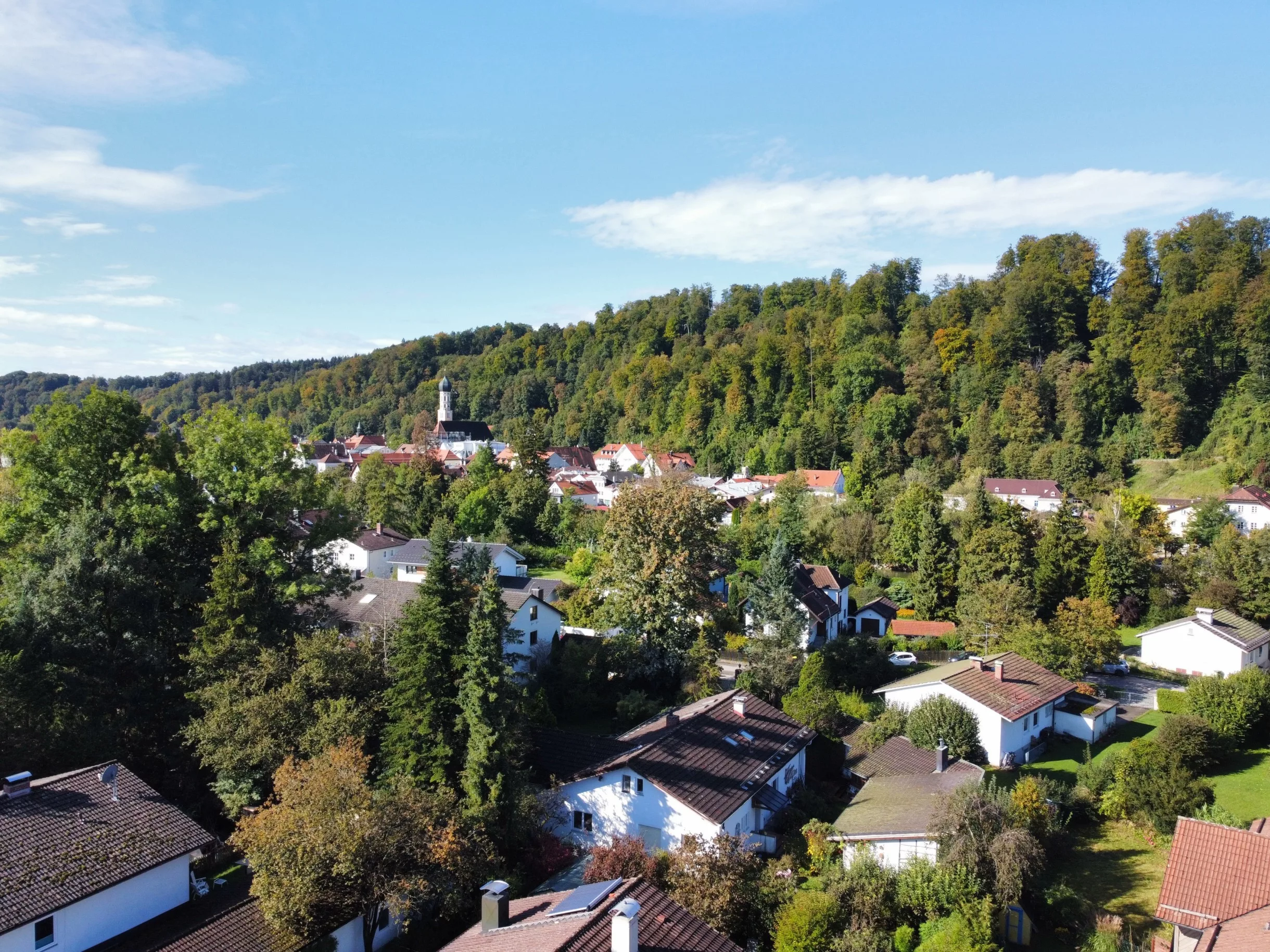 Landschaft von Wolfratshausen mit Häusern und Wald im Hintergrund