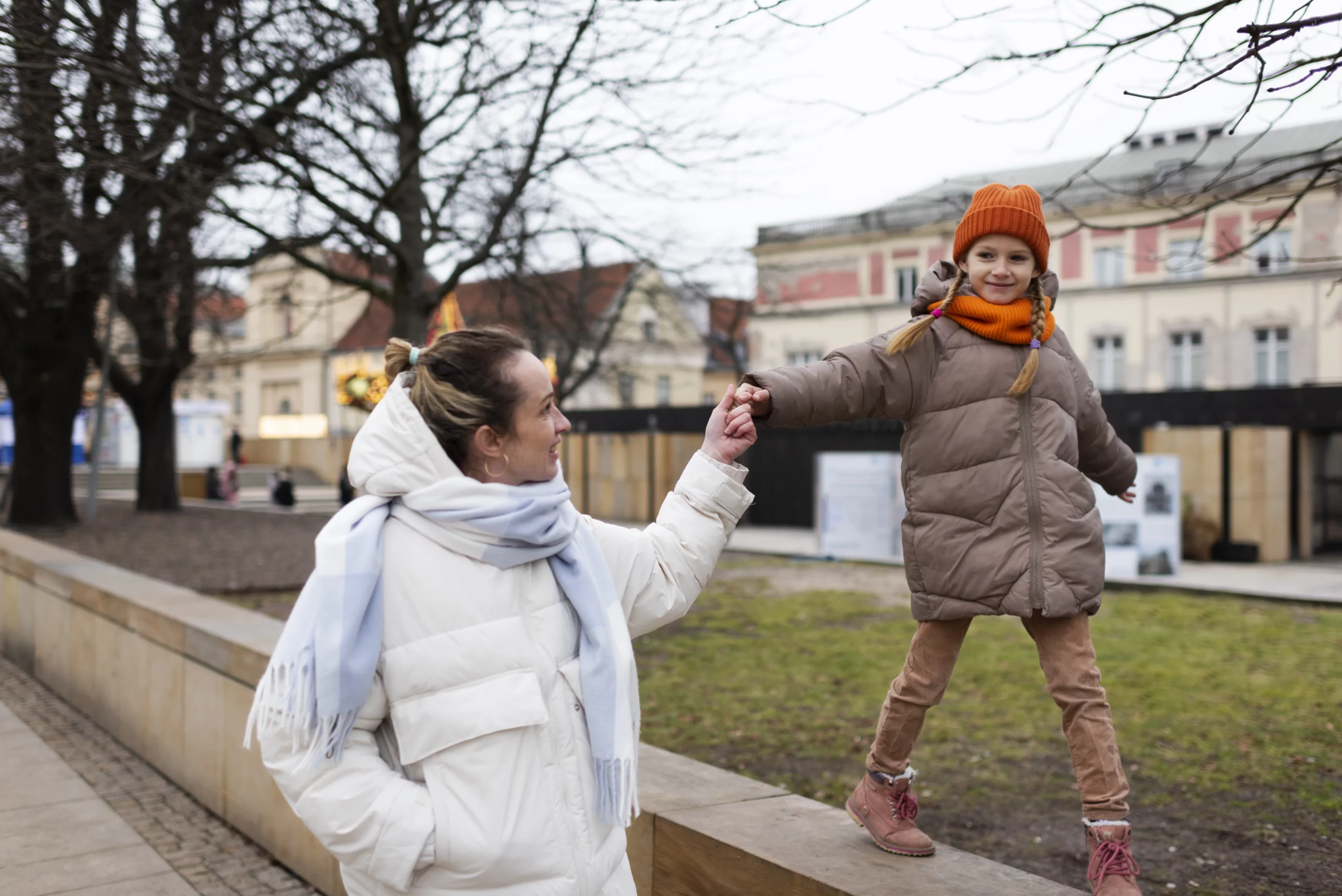Erwachsene und Kind spielen im Freien.