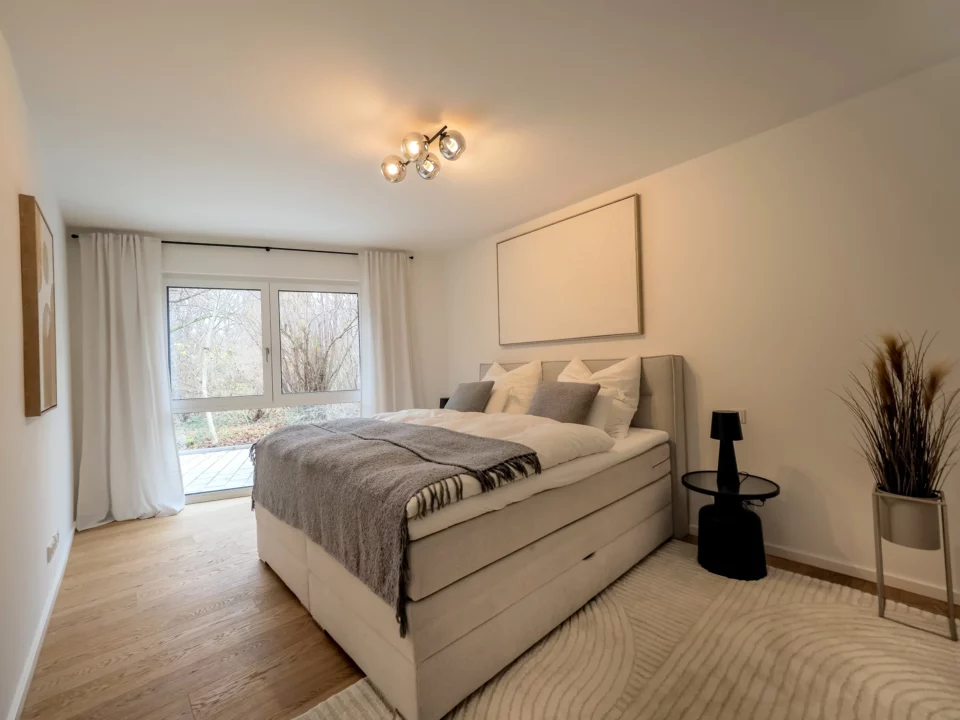 Helles Schlafzimmer mit Fenster und gemütlichem Bett