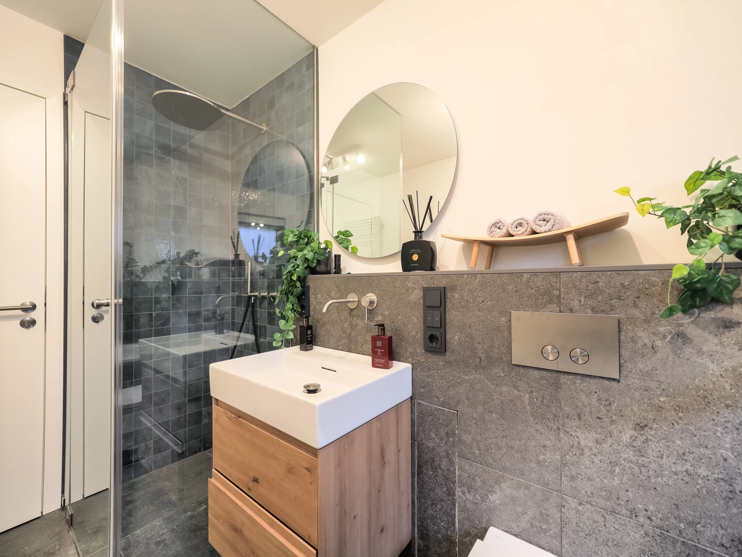 Modernes Badezimmer mit Pflanzen und eleganter Ausstattung.