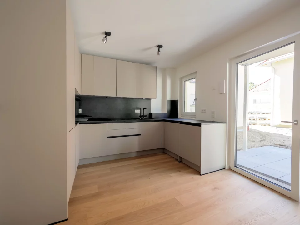 Moderne, helle Küche mit großen Fenstern.