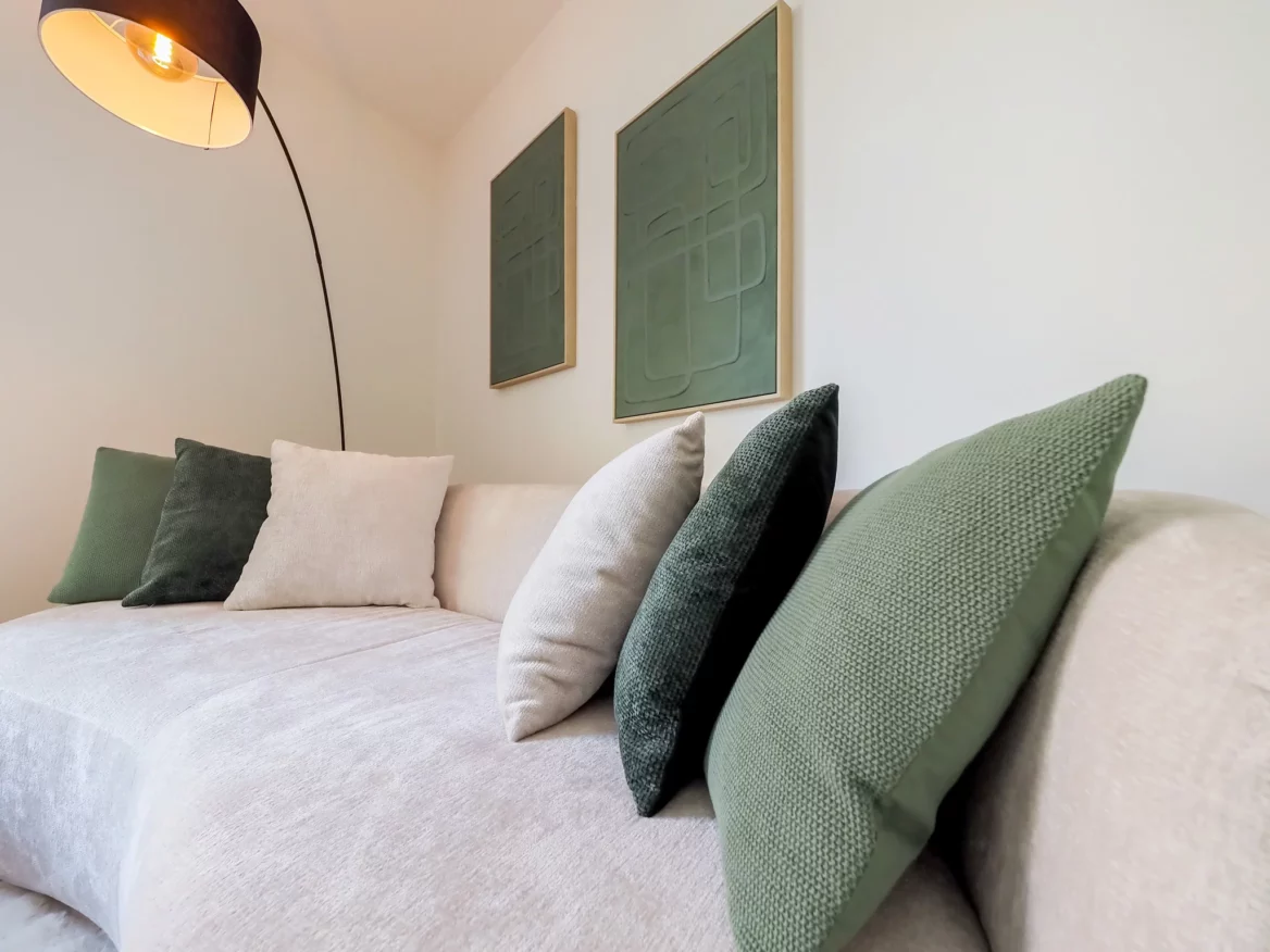 Gemütliches Sofa mit dekorativen Kissen und Lampe