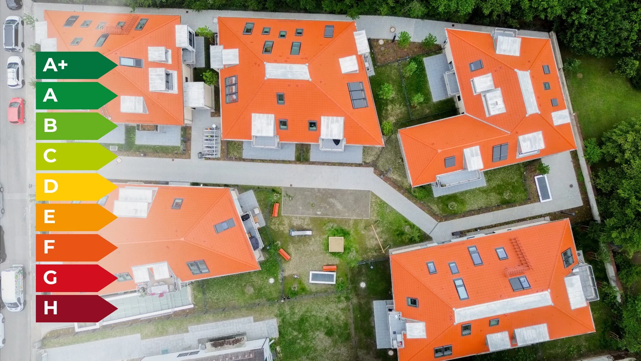 Luftaufnahme moderner Wohnhäuser mit Energieeffizienzskala