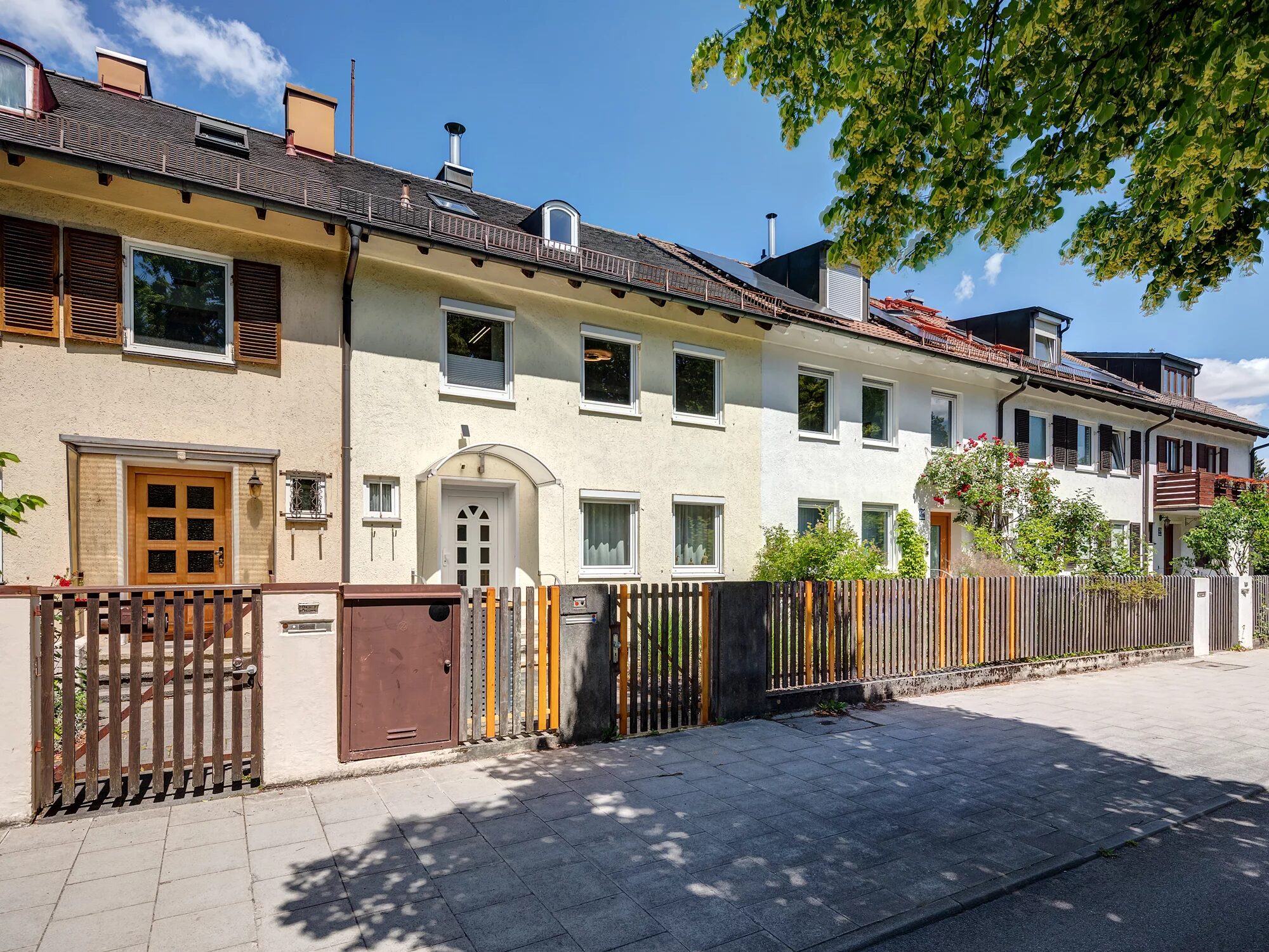 Reihenhäuser mit weißer Fassade und Holzzaun