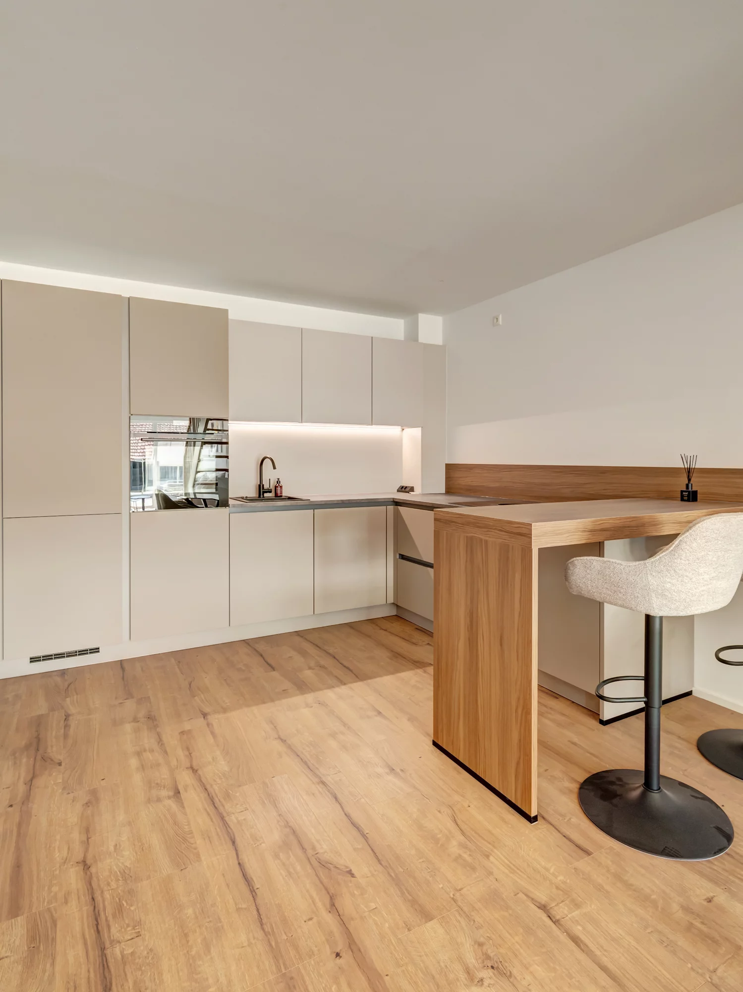 Moderne minimalistische Küche mit Holztheke und Barhocker