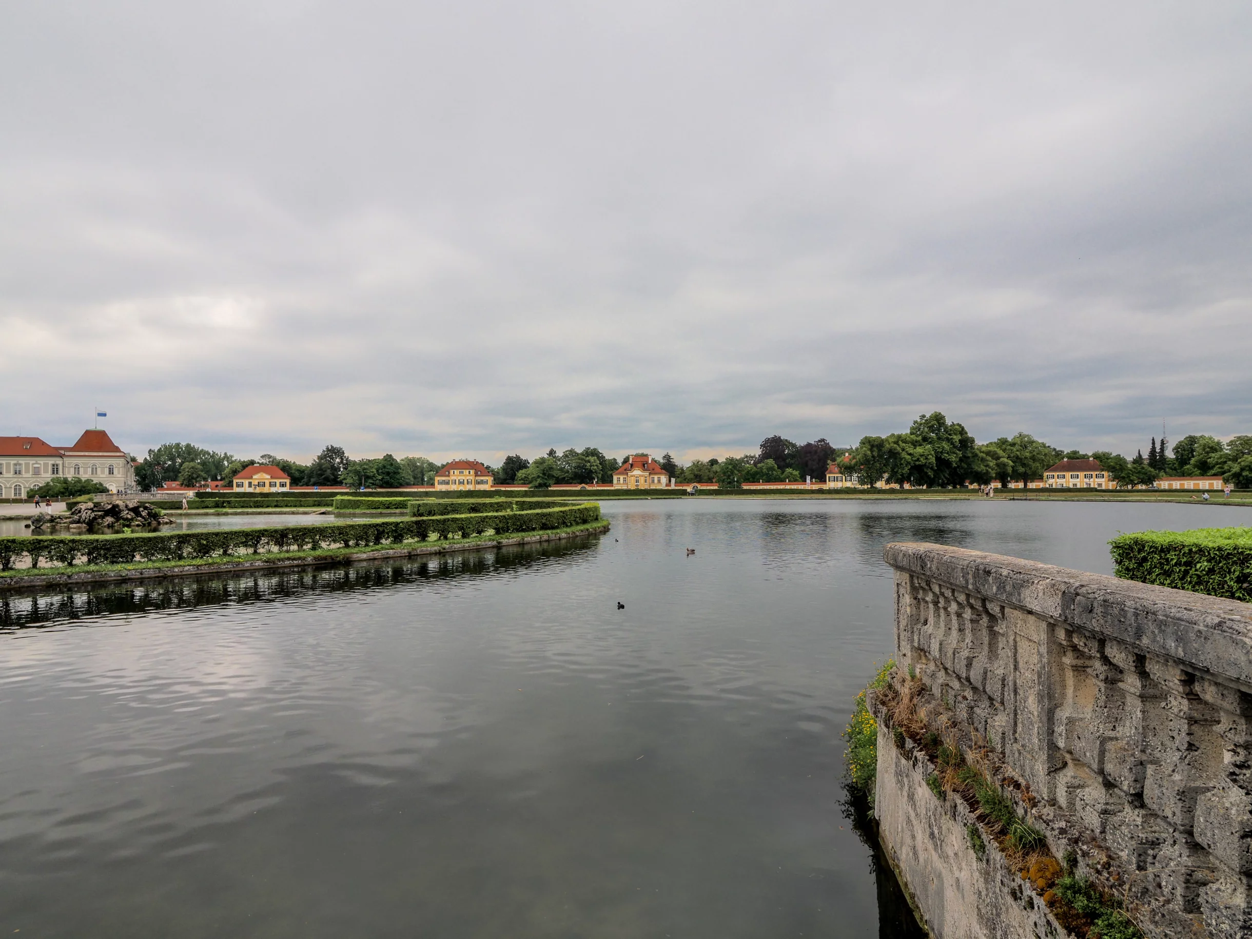 Schlosspark mit See und barocken Gebäuden
