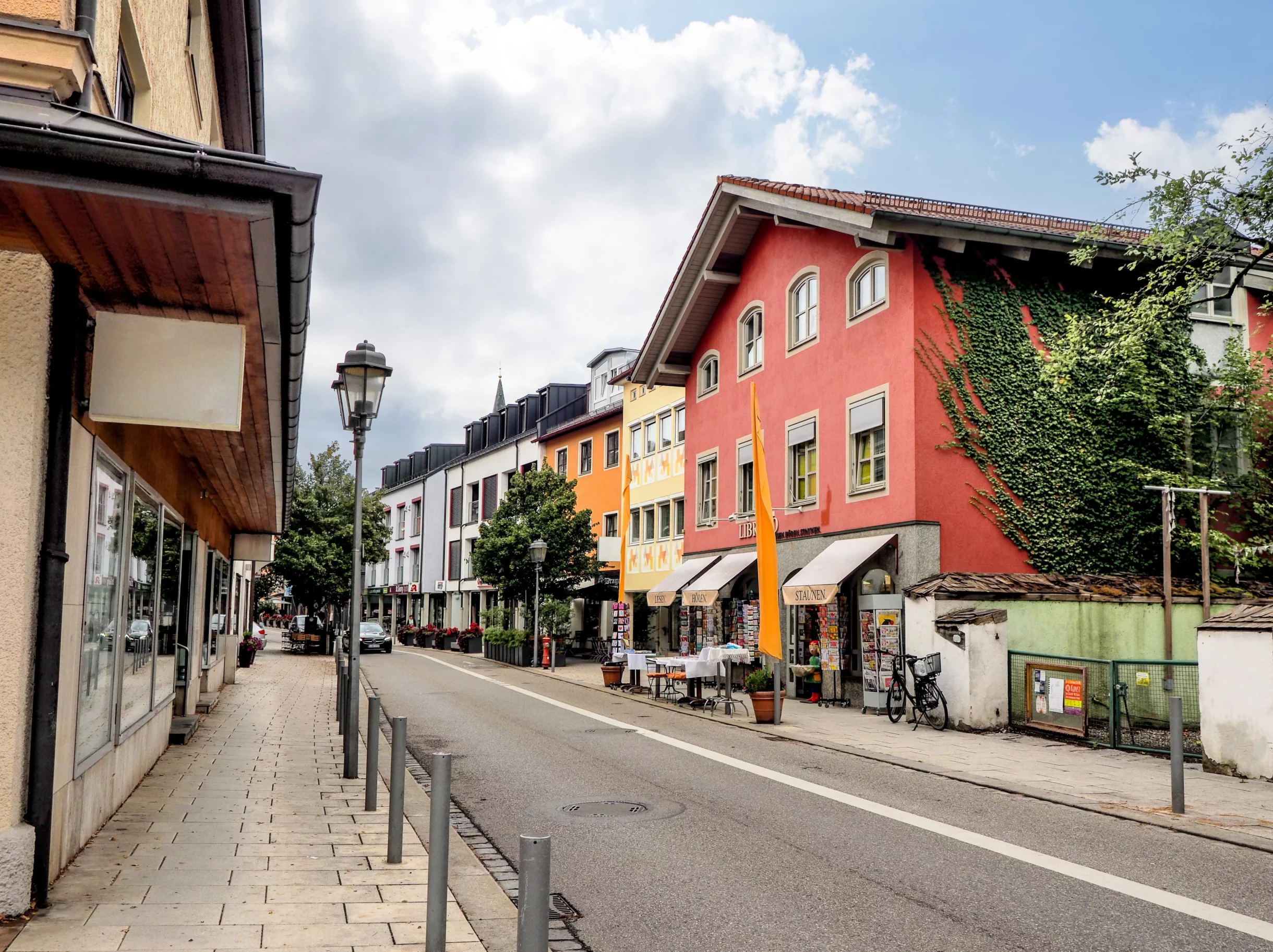 Belebte Geschäftsstraße mit bunten Häusern und Buchladen